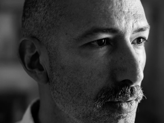 A middle-aged Syrian-Peruvian man with buzzed salt-and-pepper hair and mustache wearing a button down shirt.