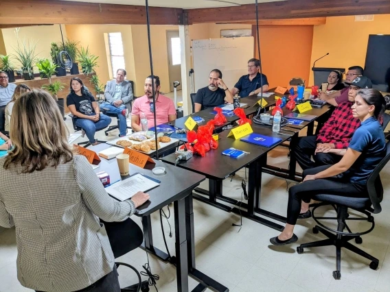 people gathered around a conference table watching a presentation